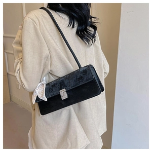 Detail of black velvet shoulder bag with silver buckle and decorative printed silk scarf