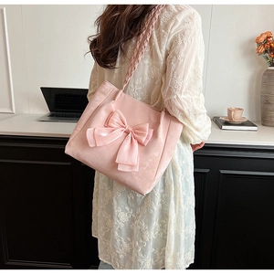 Detail der rosa Satintote mit großer Schleife und geflochtenem Schultergurt