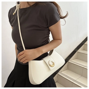 Detail view of the white PU leather crescent bag with gold magnetic buckle and knotted strap