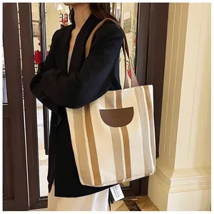 Detail of canvas tote bag showing striped pattern and brown Speed Mail leather patch