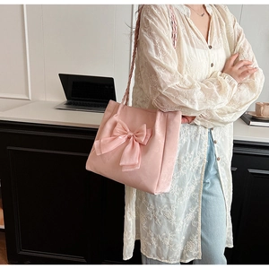 Seitenansicht der rosa Shopper-Tasche mit Schleife und gewebtem Riemen an Model
