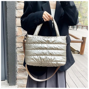 Detail of silver quilted metallic tote with side buckles and nylon wide shoulder strap