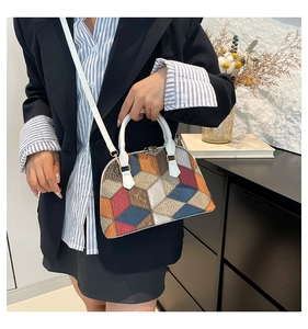 Detail shot of multi-color patchwork shell bag with crocodile texture and white handles