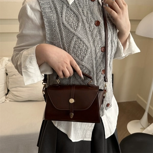 Retro dark brown leather handbag with gold twist lock shown on a model in casual style