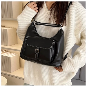 Détail du sac croissant en cuir noir avec surpiqûres contrastées et bandoulière réglable