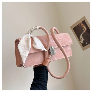Close-up of pink velvet shoulder bag with silk scarf handle and crystal square buckle
