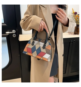 Detail of colorful geometric patchwork on a leather shell bag with gold hardware