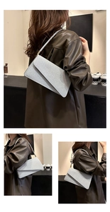 Détail du sac à bandoulière argenté brillant avec un rabat asymétrique au design moderne