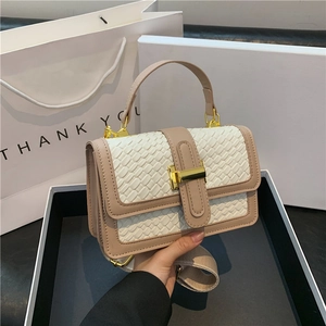 Détail du sac à main tissé blanc avec bordure beige et boucle en métal doré poli