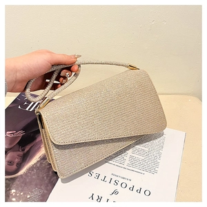 Détail d'une pochette de soirée champagne dorée avec strass scintillants et poignée en cristal