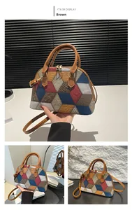 Detail view of brown shell bag with geometric multi-color patchwork and metal zippers