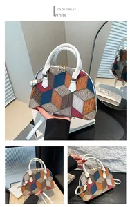 Detail of color-blocked shell bag featuring 3D geometric patterns and white handles