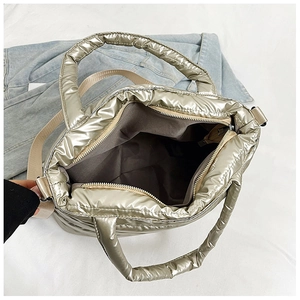 Detail view of metallic champagne gold quilted tote bag with top zipper and inner lining