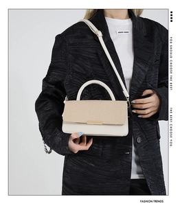 Détail du sac bandoulière avec rabat tressé et finition en cuir beige lisse élégant