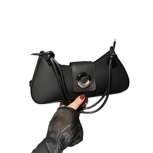 Minimalist black baguette shoulder bag with stylish round metal buckle and cord strap