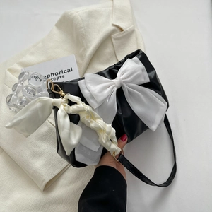 Large black pleated shoulder bag with oversized white organza bow and satin ribbon