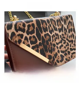 Close-up of leopard print flap and gold chain detail on fashion crossbody bag