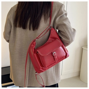Vue détaillée du sac en cuir rouge avec surpiqûres blanches et boucle en métal argenté