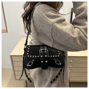 Détail d'un sac punk noir avec des rivets argentés et une large boucle de ceinture