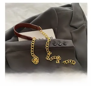 Detail of leopard print bag featuring gold metal chain and brown leather shoulder strap