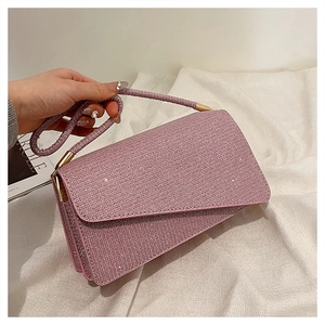 Détail du sac de soirée rose strassé avec texture de tissu élégante et accents métalliques dorés