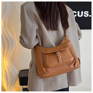 Vue latérale détaillée du sac à bandoulière en similicuir marron avec boucle sur un mannequin