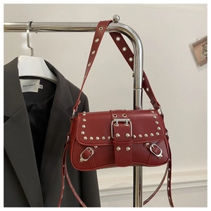Détails du sac punk en cuir rouge avec rivets et boucles argentés sur un support