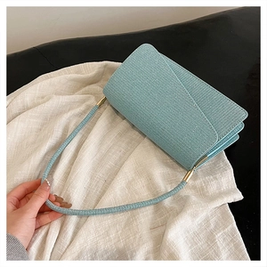 Détail du sac sous le bras bleu clair avec texture cristalline et garnitures dorées