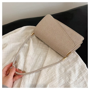 Détail de la pochette de soirée dorée à strass avec bandoulière scintillante et fermoir aimanté