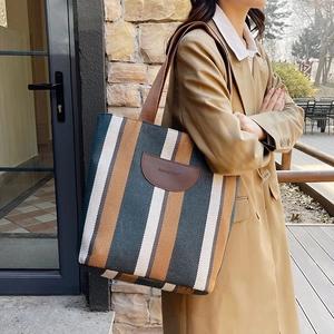 Chic striped canvas bucket bag for women with brown leather patch and woven strap