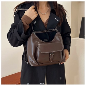 Détail d'un sac hobo vintage marron foncé avec surpiqûres et boucle en métal argenté