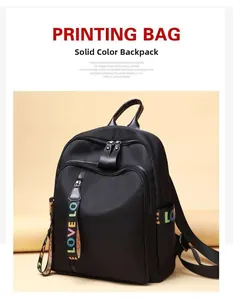 Detail of black nylon backpack featuring colorful LOVE LO lettered ribbon and front zipper