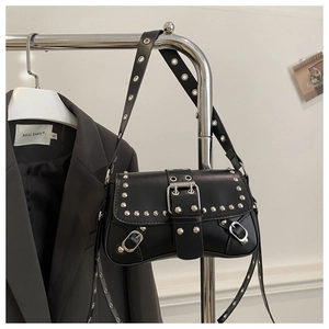 Détail du sac bandoulière punk en cuir noir avec clous argentés et boucles en métal