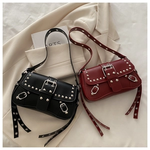 Gros plan de sacs baguette punk rétro noir et rouge avec des rivets et des boucles en métal