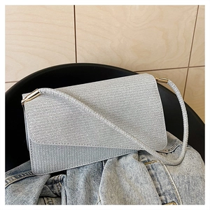 Gros plan d'un sac argenté scintillant avec un éclat métallique et boucle dorée