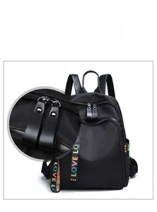 Detail of black backpack featuring dual zippers with leather-feel pullers and LOVE strap