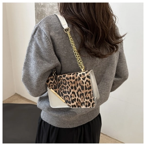 Close-up of leopard print shoulder bag with golden chain and metallic buckle detail