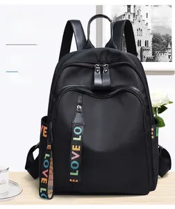 Detail of waterproof black nylon backpack with multi-zipper layers and lettered webbing