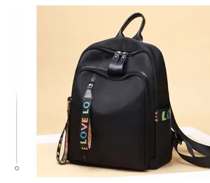 Detail showing high-quality black nylon backpack with multi-zipper and LOVE woven strap