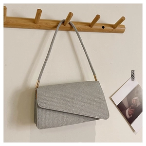 Détail du sac à bandoulière argenté scintillant avec rabat et finitions métalliques