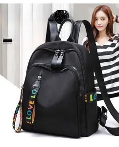 Detailed view of black nylon backpack with colorful LOVE letter ribbon and dual zippers