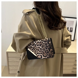 Chic leopard print crossbody bag with gold chain strap styled on a beige trench coat