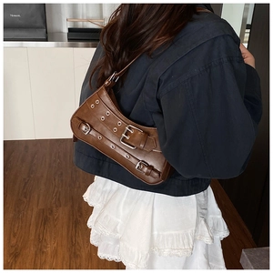 Detailed view of dark brown vintage faux leather shoulder bag with silver metallic eyelets