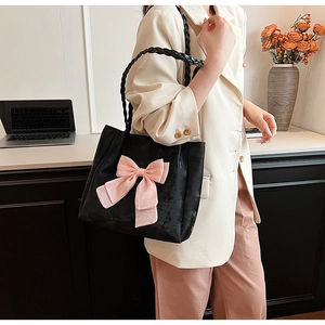 Detailansicht der großen schwarzen Shopper-Tasche mit rosa Schleife im Büro-Ambiente