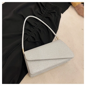 Détail de la texture argentée scintillante et boucle dorée sur ce sac à bandoulière