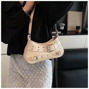 Detail of beige underarm bag with silver buckles and grommets on synthetic leather