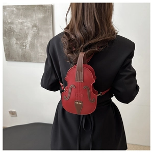 Detail view of a creative violin shaped crossbody bag in red with brown neck and gold studs