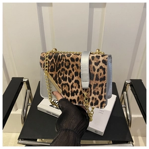 Detail view of leopard print crossbody bag with gold chain strap and silver buckle
