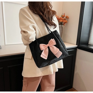 Seitenansicht der großen schwarzen Samt-Tote-Bag mit rosa Satinschleife an der Schulter