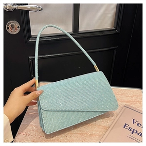 Vue détaillée d'un sac à main bleu clair pailleté avec texture strass sur marbre